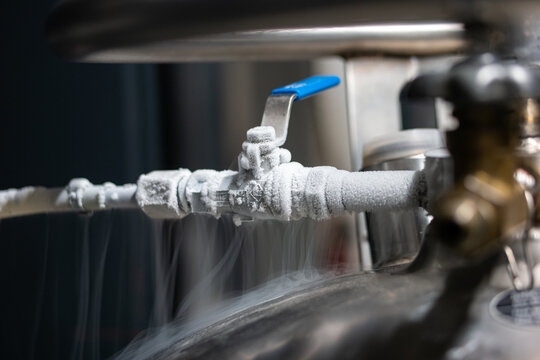 Liquid nitrogen frozen faucet and lever. Visible floating white condensation smoke from pressurized tank isolated close up shot