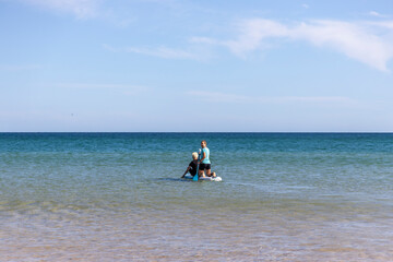 Friends enjoying stand up paddling on the Atlantic Ocean in Portugal