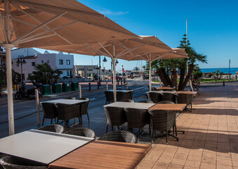 Empty tables and chairs in a bar in Moraira, Alicante (Spain).