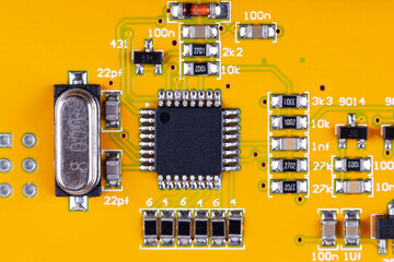 electronic printed circuit board, microchip in the middle, on yellow PCB