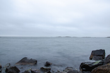 Long exposure photo of beautiful cold ocean waves and rocks. Seasonal. Swedish West coast.