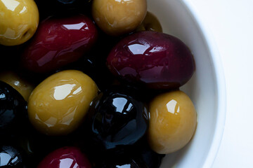 Different kinds of organic ripe olives on oil macro close up