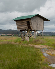 Vertical shot of a wooden hut in a rural area on a cloudy day