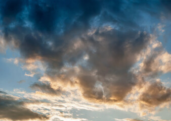 Naklejka na ściany i meble Dramatic Clouds in Evening Light of Sunset on Blue Sky Background - Overcast Western Sky in Spring Dusk Time - Belarus Minsk