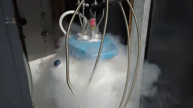 White condensation vapor flowing down from liquid nitrogen tank with metal piping