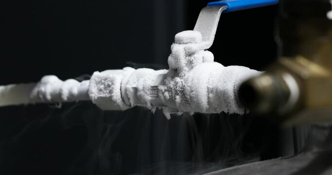 Liquid nitrogen frozen faucet and lever. Visible floating white condensation smoke from pressurized tank isolated close up shot