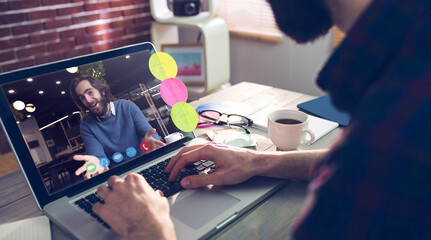 Caucasian businessman sitting at desk using laptop having video call with male colleague