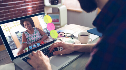 Caucasian businessman sitting at desk using laptop having video call with female colleague