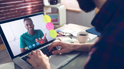 Caucasian businessman sitting at desk using laptop having video call with male colleague