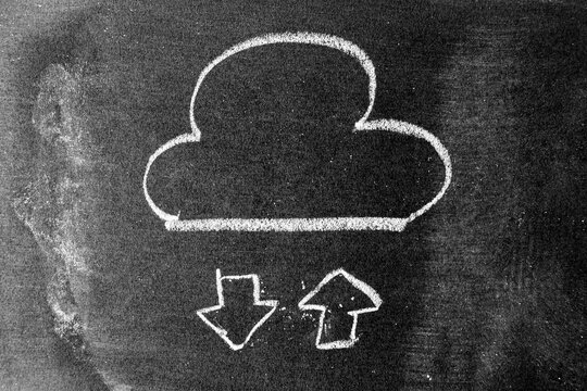 White chalk hand drawing in cloud with up and down arrow icon shape on blackboard or chalkboard background (Concept for cloud computer download and upload data, connection or transfer data)
