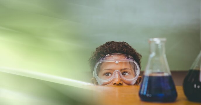 Composition of african american boy in lab with flasks, wearing goggles with motion blur