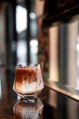 Close-up of iced coffee served on black table at cafe​