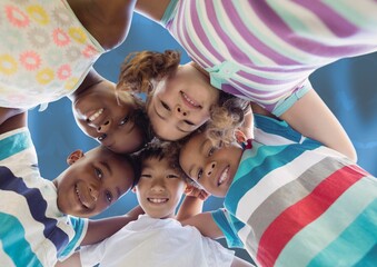 Composition of schoolchildren smiling and hugging over blue background
