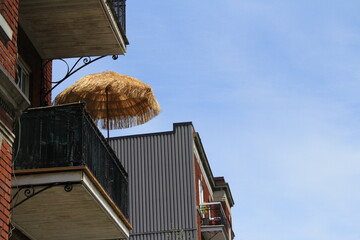 Sun umbrella in Canada, in Montreal on a sunny day on the urban balcony, symbol of Covid-19...