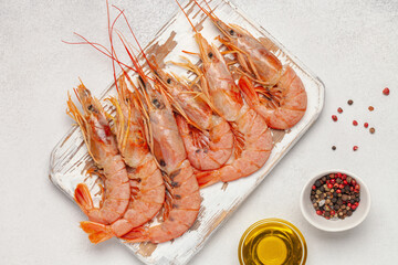 Seafood raw langoustines with olive oil and spices on a wooden board. Top View