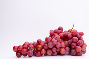 Red grapes isolated on white background. Fresh bunch of fruits. Selective focus
