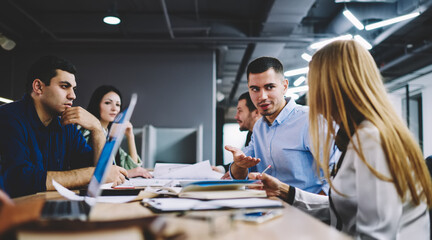 Smart casual colleagues discussing startup project during brainstorming collaboration at table desktop, talented employees talking about business strategy during working time in office interior