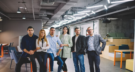 Half length portrait of confident male and female partners looking at camera during collaborative meeting for brainstorming indoors, smart casual executive managers posing during working day