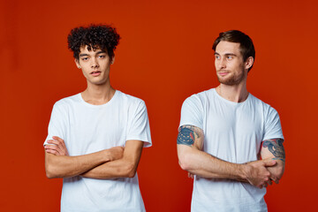 two friends in white t-shirts stand side by side isolated background communication