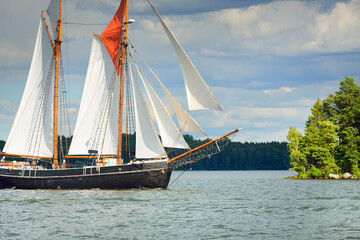 An elegant two-masted gaff schooner (training tall ship) sailing in Mälaren lake, Sweden. Travel, history, traditions, transportation, sailing, sport, cruise, regatta, teamwork. Panoramic view