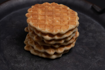 waffles cookies in a black tray on a black background, top view.