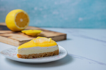 Triangular lemon cheesecake on gray marble background