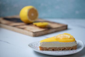 Triangular lemon cheesecake on gray marble background