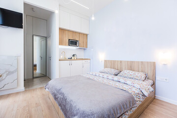 Interior photography, modern bedroom, with large stylish bed, modern design, whith small kitchen