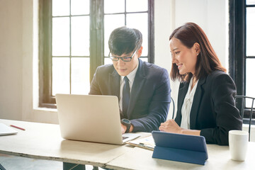 Fototapeta premium Asian businessman and his secretary woman working with laptop for strategy business plan in home office., co-working space concept