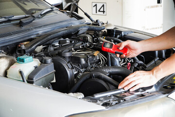 Mechanic is using a diagnostic car code reader.