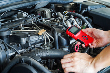 Mechanic is using a diagnostic car code reader.