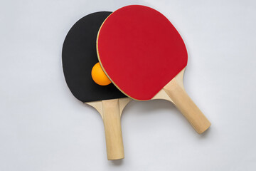 Table tennis racket on white background, with orange table tennis ball.