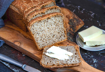 Homemade whole grain bread with with seeds. A piece of bread with butter