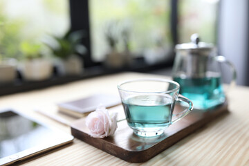 Butterfly pea tea juice and rose on wooden table