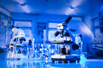 Coronavirus pandemic theme. Science research concerning fast covid tests and anti-covid vaccine. Microscope, beakers and test tubes in the scientific laboratory.