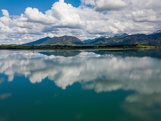 Forggensee Allgäu from above - Aerial view with mirroring clouds on a sunny day at the feet of the...