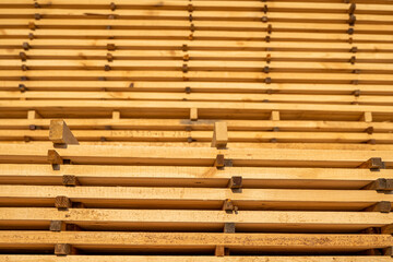 Storage of piles of wooden boards on the sawmill. Boards are stacked in a carpentry shop. Sawing drying and marketing of wood. Pine lumber for furniture production, construction. Lumber Industry.