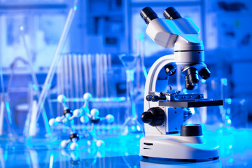 Coronavirus pandemic theme. Science research concerning fast covid tests and anti-covid vaccine. Microscope, beakers and test tubes in the scientific laboratory.