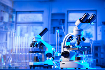 Coronavirus pandemic theme. Science research concerning fast covid tests and anti-covid vaccine. Microscope, beakers and test tubes in the scientific laboratory.
