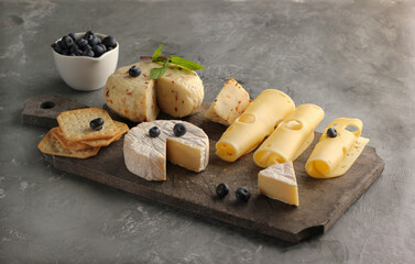 Assortment of cheese and berries on a gray background