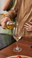 Hands of homosexual male partner pouring wine into glass