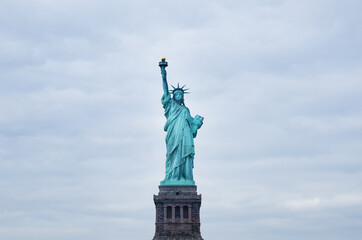 Fototapeta na wymiar Statue of Liberty on the background of cloud sky.