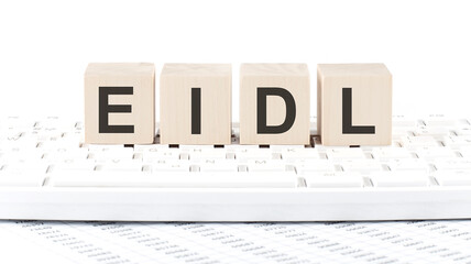 EIDL -word wooden block on keyboard background witn chart