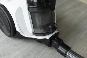 Bagless cyclone vacuum cleaner on a grey tile. Electrical apparatus that by means of suction...