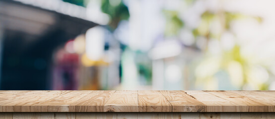 Empty wood table and blurred light table in coffee shop and cafe with bokeh background. product display template.