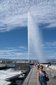 Smiling woman in front of the water jet of Geneva