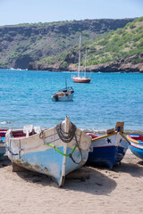 Fototapeta na wymiar Barcas de pescadores y velero en la playa de Tarrafal en la isla de Santiago de Cabo Verde