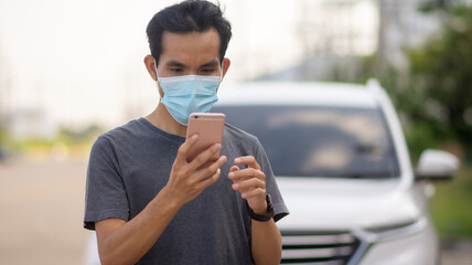 Asian man wear facemask protect covid19 coronavirus outbreak and using smartphone lifestyle outdoor street urban