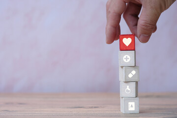 Hand arranging  wood cubes with medical icon and healthcare concept