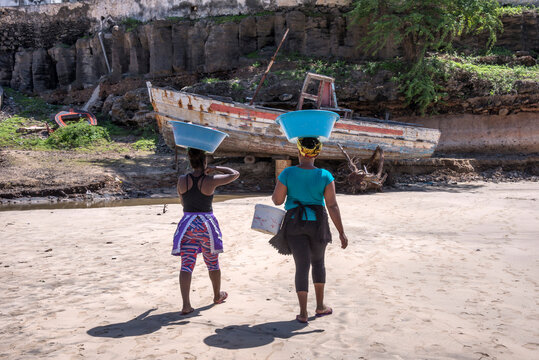 Mujeres transportando pescado en la playa de Tarrafal en  la isla de Santiago en Cabo Verde